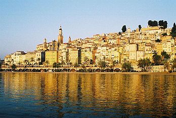 Le front de mer et la promenade bordée de palmiers près du port, face à la vieille ville de Menton dans les Alpes-Maritimes (France) ; en arrière-plan le campanile de la basilique Saint-Michel domine le port. (définition réelle 1 044 × 699*)