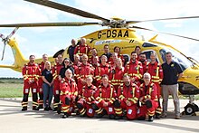 Members of the Dorset and Somerset Air Ambulance Team in front of their yellow AW169 helicopter.