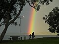 Rainbow after sunlight bursts through after an intense shower in Maraetai, New Zealand