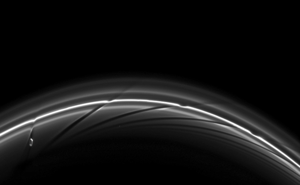Prometheus near apoapsis carving a dark channel in the F Ring (with older channels to the right). A movie of the process may be viewed at the Cassini Imaging Team website[158] or YouTube.[159]