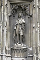 Photo de la statue d'un roi en pied, avec couronne et sceptre, pourtant une église symbole de sa fondation.