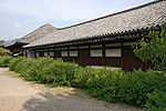 Long bâtiment en bois avec des murs blancs.