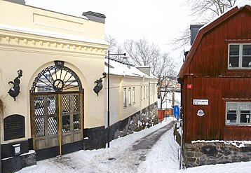 Duvogränd på Södermalm sedd från Ludvigsbergsgatan mot norr. Till vänster på bilden syns den eleganta entrén till Villa Ludvigsberg som uppfördes 1859–1860 efter ritningar av arkitekt Johan Fredrik Åbom för Jacques Lamm, ägaren av Ludvigsbergs Mekaniska Verkstad. Till höger ligger fastigheten Ludvigsberg 14 med trähusbebyggelse från 1750-talet.