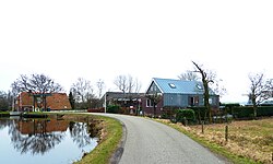 Buurtje rond de Nijveensterkolk met rechts op de achtergrond de poldermolen De Helper