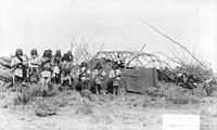 "Scene in Geronimo's camp before surrender to General Crook, March 27, 1886: group in Natches' camp; boys with rifles."