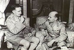 羅遜准將（圖中右方）與莫德庇少將正在討論香港防務。羅遜隨加拿大援軍於1941年11月16日抵達香港，莫德庇於12月12日決定將「港島旅」分為「東旅」及「西旅」後，羅遜負責指揮香港島的西旅部隊，而從新界及九龍撤到港島的原「大陸旅」指揮官華里士准將則負責指揮東旅部隊。羅遜准將於12月19日在黃泥涌峽帶領部下從被日軍包圍的西旅指揮部突圍時戰死。