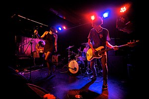 Joanna Gruesome playing on stage, with George Nicholls and Lan McArdle in the foreground.