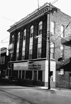 Three-story brick building with detailed cornice along the roof