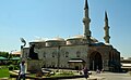 Side view of the mosque, showing the domed prayer hall preceded by a portico (right)