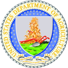 The Seal of the United States Department of Agriculture - the name of the department in a circle around a shield, which shows a plough and haystack on a gray field, with stylised grass or plants in the bottom third.