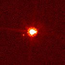 哈伯太空望遠鏡拍攝的鬩神星 (中央)和鬩衛一 (中央偏左)。