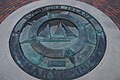 A visitors' wayfinding compass-marker on Solomons Island picturing a bugeye boat