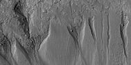 Close view of gullies from previous image The channels are quite curved. Because channels of gullies often form curves, it was thought that they were made by flowing water. Today, it is thought that they could be produced with chunks of dry ice. The image is from HiRISE under HiWish program.