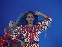 A woman stands with a microphone