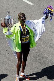 O queniano Wesley Korir ergue o seu troféu de campeão de 2012.