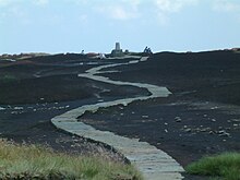 Photograph of a stone path laid across boggy ground