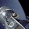 Komandomodula piloto David R. Scott kosme helpas interligiĝon de la Komando-Servo-Modulo kun la Luna Modulo