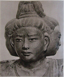 Portrait d'une sculpture à trois faces pointant vers l'avant et des deux côtés.