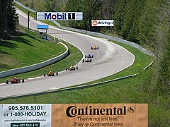 A line of Formula Ford cars climb the hill through turn 5(c)