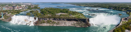 Photographie panoramique couleur. Paysage avec vaste cours d'eau s'écoulant en deux cascades.