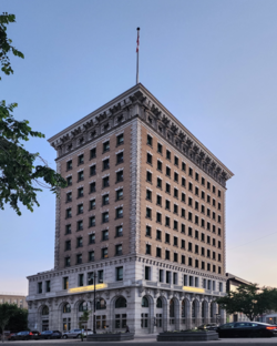 11 storey building featuring ornate stonework on the lower floors and brickwork above, with additional ornate design just below the flat roof.