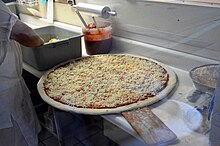 Characteristically large New York–style pie ready to go into the oven