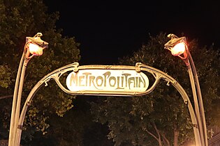 Le portique de l'édicule Guimard de la station, vu de nuit.