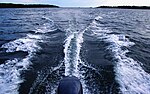 Svallvågor från en motorbåt med utombordsmotor