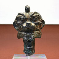 A bronze Pazuzu head, including a loop to be strung onto a necklace and worn as a protective charm.
