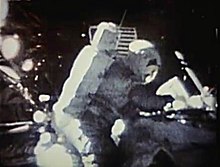 在月球上拍摄的图片，显示一名宇航员正在标记一个信封（由于照片清晰度不高，信封无法被看见）