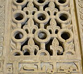 Photographie montrant les ajourages d'un panneau en marbre blanc, sculpté et percé, de la paroi du mihrab.