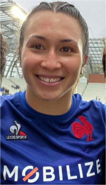 Jeune femme aux cheveux clairs plaqués, en maillot bleu de l'équipe de France.