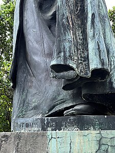 The sculptor's name at the base of the statue.