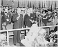 Presidents Dutra and Truman sampling a birthday cake decorated with Brazilian and U.S. flags.