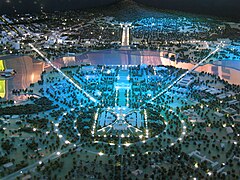 Vue nocturne sur l'axe des parlements (maquette) : le nouveau parlement au premier plan, puis l'ancien. Derrière le lac Burley Griffin se dessine Anzac Parade, menant à l’Australian War Memorial.