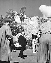 Image of Hitchcock pictured under Mount Rushmore during the filming of North by Northwest