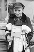 Ung gateselger i jødegettoen i Warszawa 1941 tilbyr blant annet armbind med jødestjerne. Foto: Deutsches Bundesarchiv