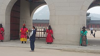 Faible nombre de touristes à Gyeongbokgung. Des masques sont intégrés à la tenue des gardes du palais.