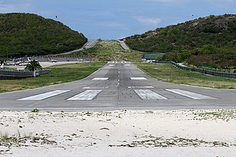 Landningsbanan på Saint Barthélemys flygplats med berg i bakgrunden.