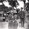 Image 8Temne leader Bai Bureh seen here in 1898 after his surrender, sitting relaxed in his traditional dress with a handkerchief in his hands, while a Sierra Leonean West African Frontier Force soldier stands guard next to him (from Sierra Leone)