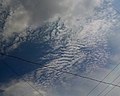 Nubes altocumulos, con una pequeña perturbacion ondulatoria en medio