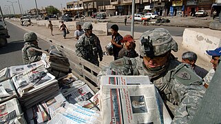 Amerikanische Soldaten verteilen die Zeitung Baghdad Now