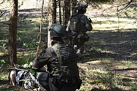 Border guard canine officer together with marine fusilier of Lithuanian Navy during military exercise.