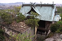 石の宝殿と本殿 手前にある巨石が神体とされている「石の宝殿」。