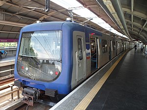 Na imagem, temos o exterior de um trem da Frota F parado com suas portas abertas na estação Giovanni Gronchi, visto de frente. Ele apresenta o padrão azul-escuro da Companhia do Metropolitano de São Paulo e tem o nome Adolfo Pinheiro em seu indicador de destino. Nota-se sua estrutura arredondada, diferente das demais frotas da Companhia à época.