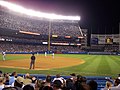 Main grandstand behind left field at night.