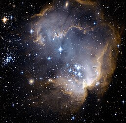 La nébuleuse NGC 602, ici photographiée par le Télescope spatial Hubble ACS, est un jeune amas ouvert d'étoiles situées dans le Petit Nuage de Magellan (SMC), une galaxie satellite de la Voie lactée. (définition réelle 3 749 × 3 659*)