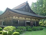 Wooden building with a hip-and-gable roof and an enclosing veranda.