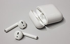 Беспроводные наушники AirPods рядом с чехлом для хранения и зарядки