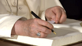 Papa Francesco indossa l'anello del pescatore mentre firma il libro degli ospiti a Palazzo di Belém, durante la sua visita in Portogallo per la GMG 2023